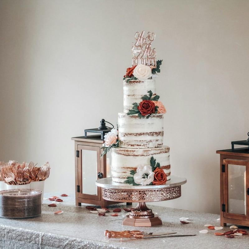 Elegant three-tier wedding cake with white fondant and gold accents